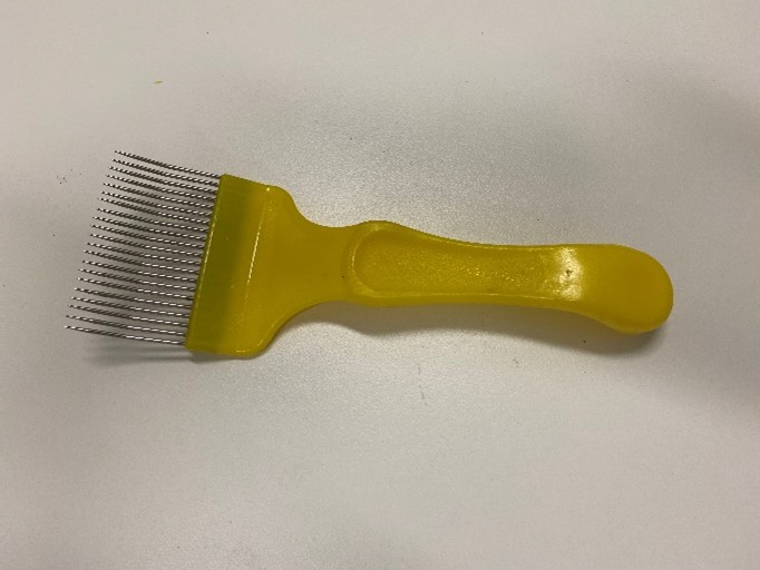 Image of a comb scratcher used to identify varroa mite as part of the drone uncapping process.